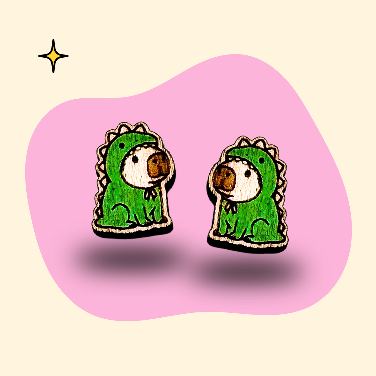 Hand-painted wooden capybara ear studs in dinosaur suits by GRAINN
